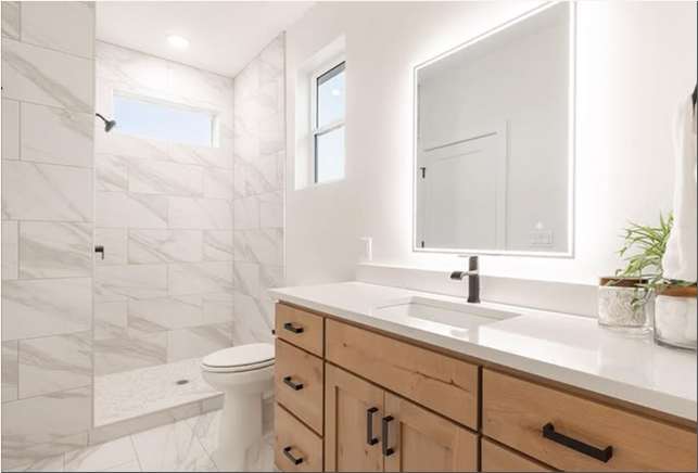 Canyon Cottage bathroom with marble-look tile shower and wood vanity