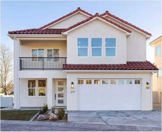 Front exterior of Canyon Cottage with a red tile roof, upper balcony and two-car garage